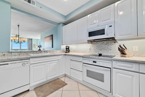 a kitchen with white cabinets and a microwave at Beach Colony East Unit 1C in Pensacola