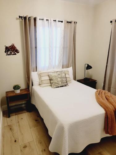 a bedroom with a white bed with a window at Encuentro Vaquero in Jarabacoa