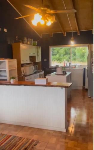 a kitchen with a white counter in a room at Casa Arrayán con vista al volcan in Frutillar