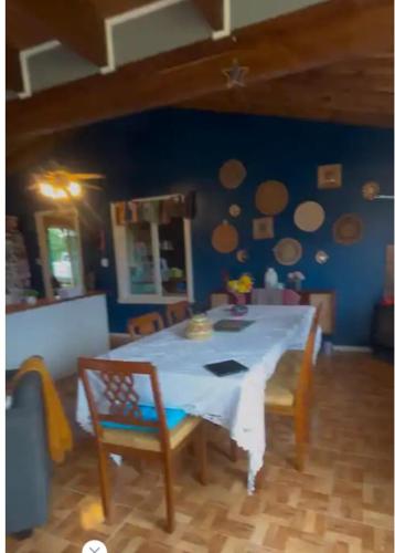 a dining room with a white table and chairs at Casa Arrayán con vista al volcan in Frutillar