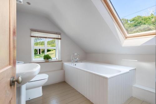 a bathroom with a white tub and a sink at 4 Bed in St. Brides oc-h30490 in Saint Brides