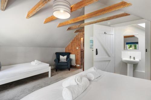a bedroom with two beds and a chair and a sink at 4 Bed in St. Brides oc-h30490 in Saint Brides
