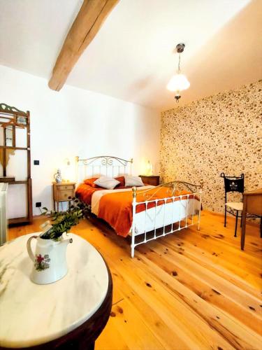 a bedroom with a bed and a table at Chambre d'hôtes La clef des Champs - LA SOURCE DE NOS RACINES - CORPS DE FERME AU COEUR DU PARC NATUREL DE L'AVESNOIS in Beaufort