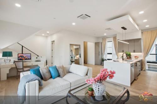 a living room with a white couch and a kitchen at Scottsdale 3BR with Private XL Rooftop, 2Car Garage, Heated Pool & Hot Tub, EV L2, 12min to Airport in Scottsdale