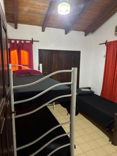 two bunk beds in a room with red curtains at Casa ByJ en El Paso in Paso de la Patria