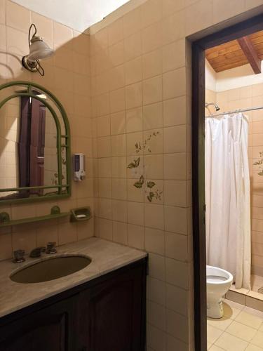 a bathroom with a sink and a mirror and a toilet at Casa ByJ en El Paso in Paso de la Patria