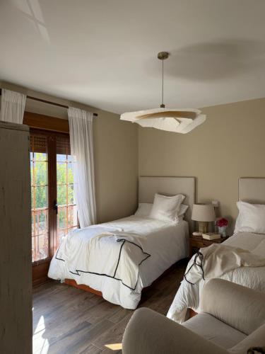 a bedroom with two beds and a window at El Corral de Tía Gloria in Pepino