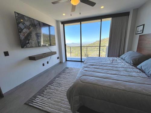 a bedroom with a large bed and a large window at Marea Sabina Luxury Ocean View & Amenities in Cabo San Lucas