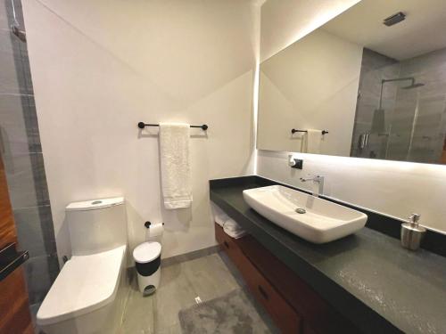 a bathroom with a white toilet and a sink at Marea Sabina Luxury Ocean View & Amenities in Cabo San Lucas