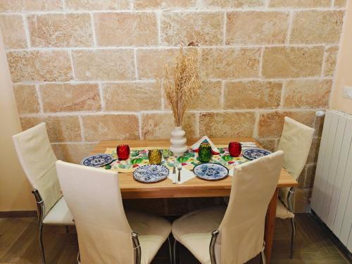 a dining room table with chairs and a stone wall at B&B Zio Cici in Minervino di Lecce