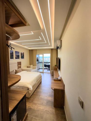 a bedroom with a bed and a living room at Chic studio with balcony, quiet & bright in Tétouan