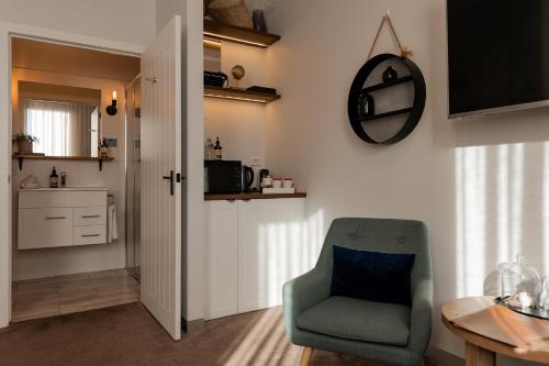 a living room with a green chair and a table at Bay Of Fires Apartments - Town Centre in St Helens