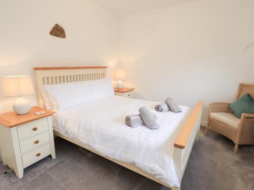 a bedroom with a white bed and a chair at Glen Lea in Settle