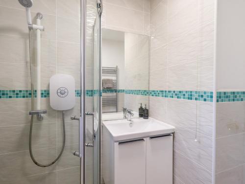 a white bathroom with a sink and a shower at Glen Lea in Settle