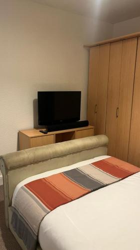 a hotel room with a bed and a flat screen tv at Workers Contractor friendly home long and short stays in Grimsby