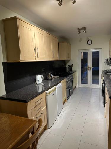 a large kitchen with wooden cabinets and white appliances at Workers Contractor friendly home long and short stays in Grimsby