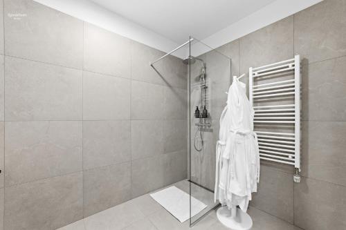 a bathroom with a shower with a white robe at Premium Ice Apartments Atlantic Ocean Magic View in Reykjavík