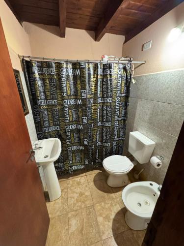 a bathroom with two toilets and a shower curtain at Cabaña UNO Refugio in Paso de la Patria
