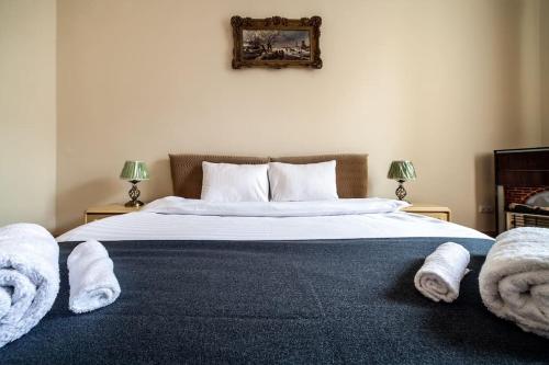 a bedroom with a large bed with towels on it at ROMANTIC Apartments - оn Valova street in Lviv
