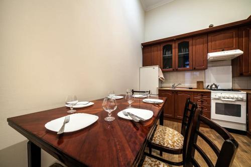 a kitchen with a wooden table with wine glasses at ROMANTIC Apartments - оn Valova street in Lviv