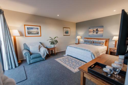 a bedroom with a bed and a chair at Manakau Lodge in Kaikoura