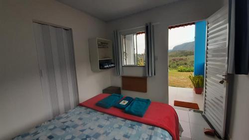 a small bedroom with a bed and a window at Chalés Canto da Graúna in Ibicoara