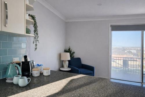 a kitchen with a counter top and a blue chair at Allawah Hideaway Tamworth in West Tamworth