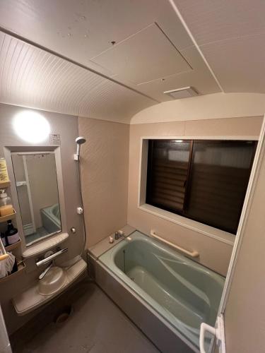 a bathroom with a tub and a toilet and a sink at HAPPY MAGIC guesthouse in Tateyama