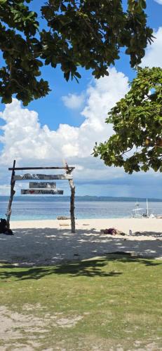 a bench on the beach with a view of the ocean at Pamilacan Vacay in Baclayon