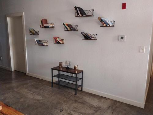 a room with a table and a wall with books at The Downtown Stadium Loft in Memphis