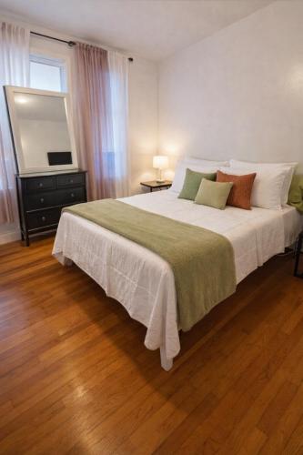 a bedroom with a large bed and a television at Bronx City Stay Private Room Near Manhattan in Kings Bridge Heights