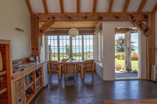 a kitchen and dining room with a table and chairs at Ahu Ahu Beach Villas in Oakura