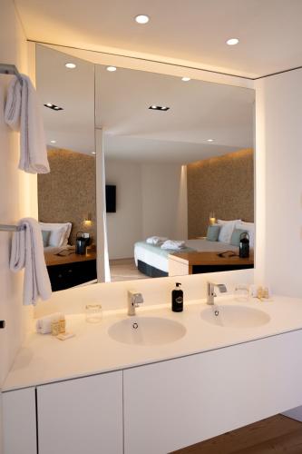 a bathroom with two sinks and a large mirror at Foz Côa Story House in Vila Nova de Foz Coa