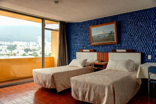 a hotel room with two beds and a window at Hotel Savoy Inn in Quito