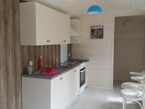 a small kitchen with white cabinets and a stove at Chata w Rabce - Bajkowa Osada in Rabka