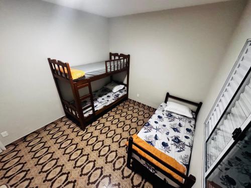 a small room with two bunk beds in it at Casa de praia in Mongaguá