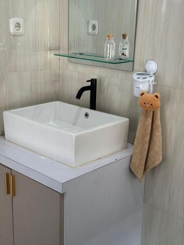 a white sink in a bathroom with a towel at d'house toraja in Rantepao