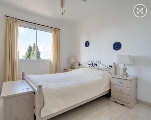 a white bedroom with a bed and a window at Newly Renovated Light House Beach 8 min in Paphos