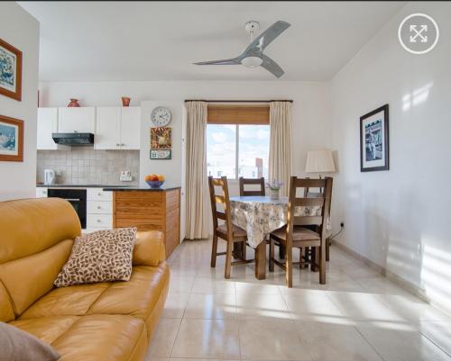 a living room with a couch and a table with chairs at Newly Renovated Light House Beach 8 min in Paphos