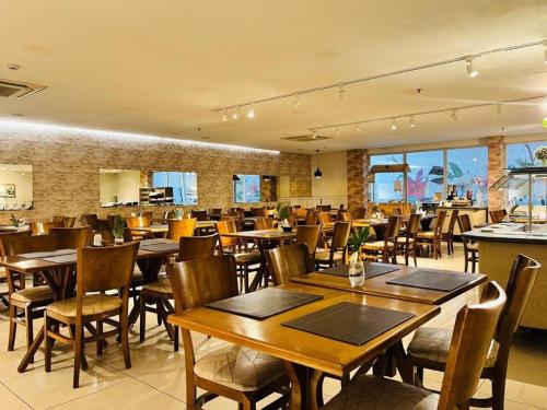 a dining room with wooden tables and chairs at Flat Premium Manaus no Adrianópolis in Manaus