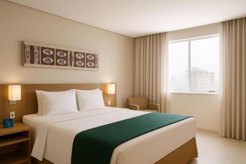 a hotel room with a large bed and a window at Flat Premium Manaus no Adrianópolis in Manaus