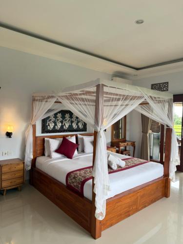 a bedroom with a bed with a canopy at Bhakti Ubud Villa in Ubud