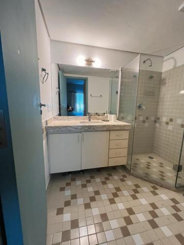 a bathroom with a sink and a shower at Flat Hotel Confort Suítes Alphaville in Barueri