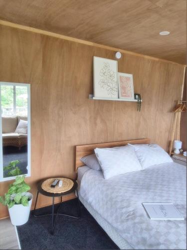 a bedroom with a bed and a table at Tide and Tranquility - Guest Studio in Snells Beach