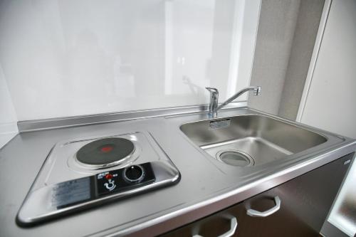 a kitchen counter with a sink and a remote control at QU302 EPrivate 2BR Home with Living Room and Kitchen, Separate Bath and Toilet, Sleeps 4 in Tokyo