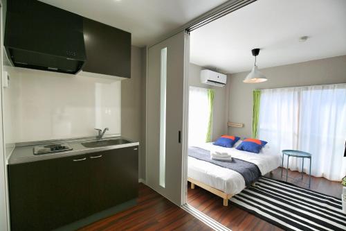 a bedroom with a bed and a kitchen with a sink at QU302 EPrivate 2BR Home with Living Room and Kitchen, Separate Bath and Toilet, Sleeps 4 in Tokyo