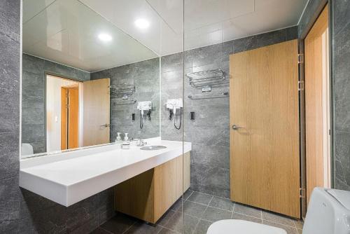 a bathroom with a white sink and a shower at Ocean2YouResort SokchoSeorakBeach Hotel&Condo in Sokcho