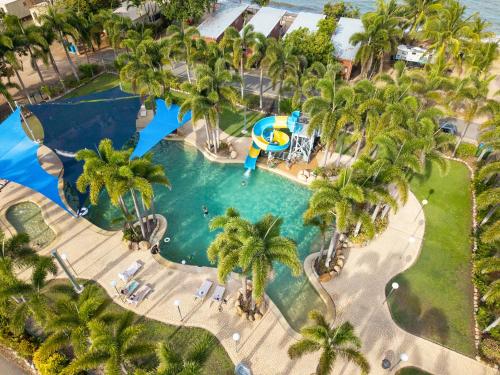 an overhead view of a pool with palm trees at Tasman Holiday Parks - Rollingstone in Rollingstone