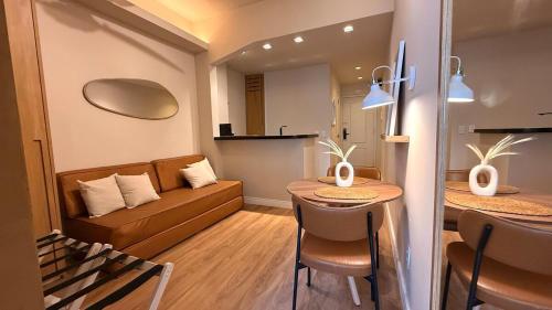 a living room with a couch and a table at Studio Quarto e Sala Moderno em Ipanema, próximo a praia in Rio de Janeiro