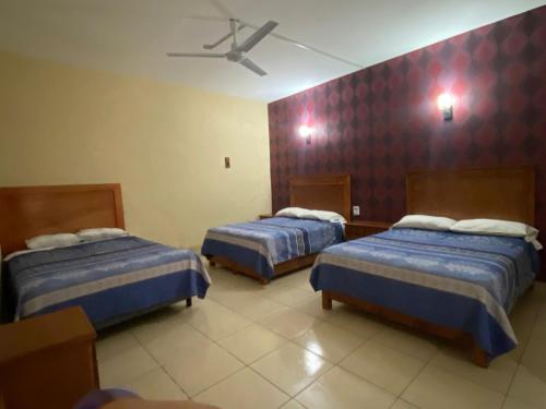 a hotel room with two beds and a ceiling at Hotel Jocari in Cholula